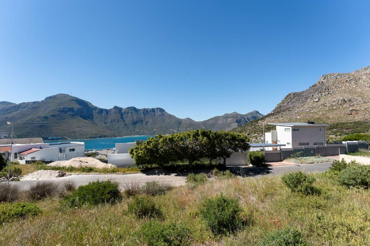 A scenic view overlooking the bay, surrounding residential neighborhood, and mountain range, showcasing the natural landscape and coastal setting of the vacant land.