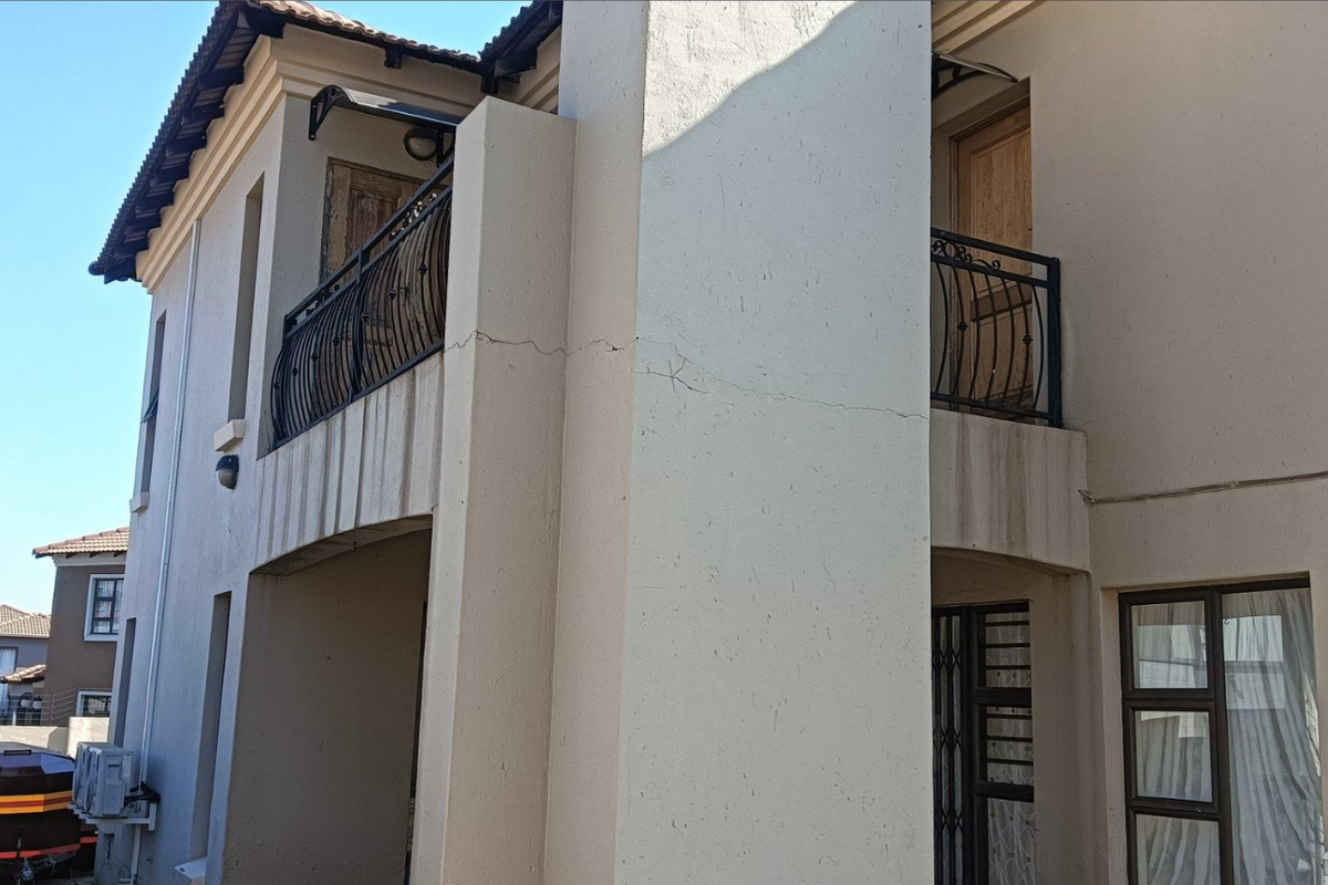Exterior view of a multi-story residential building featuring balconies with wrought iron railings and external wall finishes.