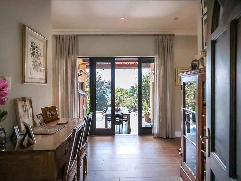 A bright living area featuring laminate flooring and large sliding glass doors that provide seamless access to the outdoor patio and garden.