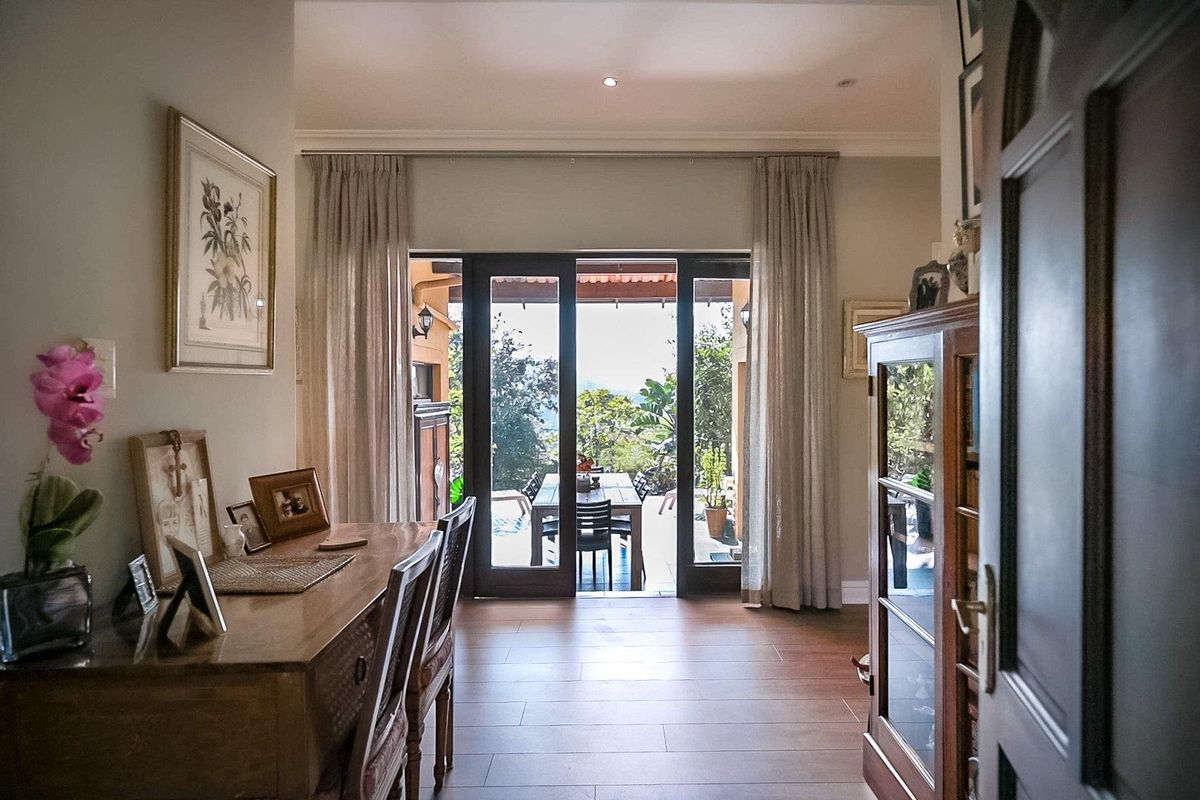 A bright living area featuring laminate flooring and large sliding glass doors that provide seamless access to the outdoor patio and garden.