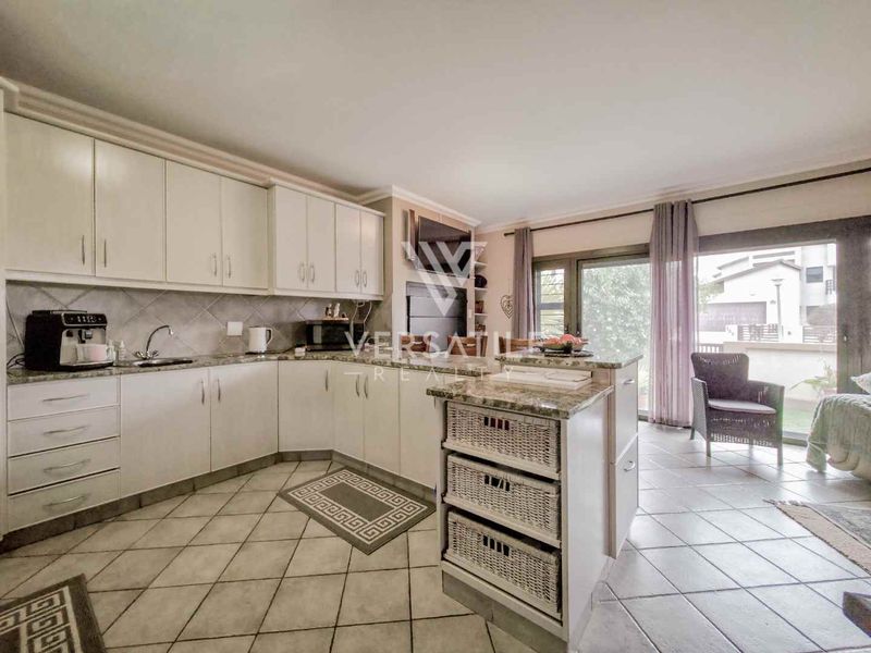 Open-plan kitchen and living area featuring granite countertops, ample cabinetry, a central island, and sliding glass doors leading to an outdoor space.
