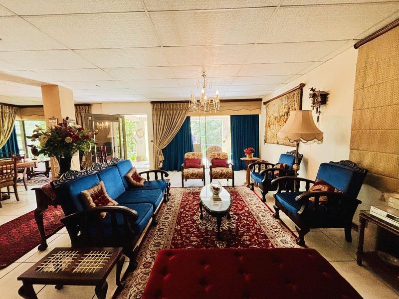 Spacious living room featuring a drop ceiling, tiled flooring, and large sliding glass doors that provide access to the outdoor area.