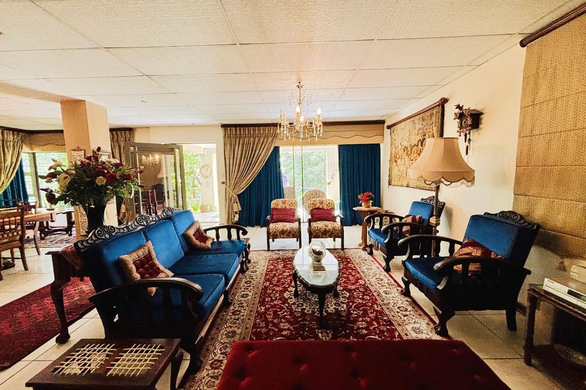 Spacious living room featuring a drop ceiling, tiled flooring, and large sliding glass doors that provide access to the outdoor area.
