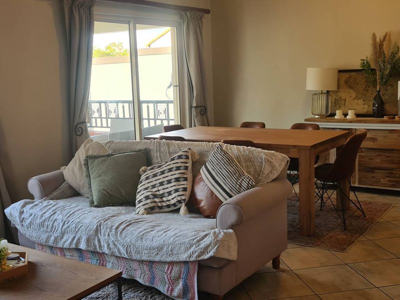 Open plan living and dining area featuring tiled flooring and large sliding glass doors providing access to the outdoor space.