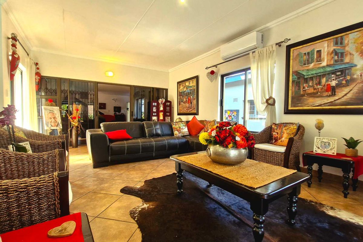 A comfortable living room featuring ceramic tiled flooring, a wall-mounted air conditioning unit, and sliding glass doors leading to an adjacent space.