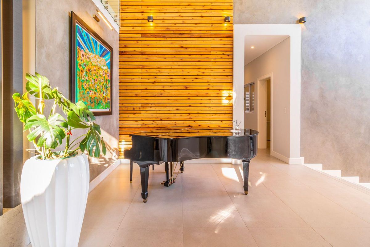 A modern living area featuring a striking timber slat feature wall, neutral tiled flooring, and elegant recessed lighting, creating a sophisticated and warm atmosphere.