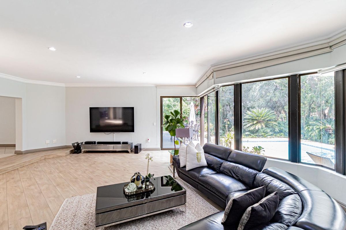 Spacious living room featuring large floor-to-ceiling windows, recessed lighting, and direct access to the outdoor patio area.