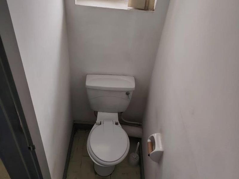 A compact, functional guest toilet featuring standard sanitary ware and a small window for ventilation.