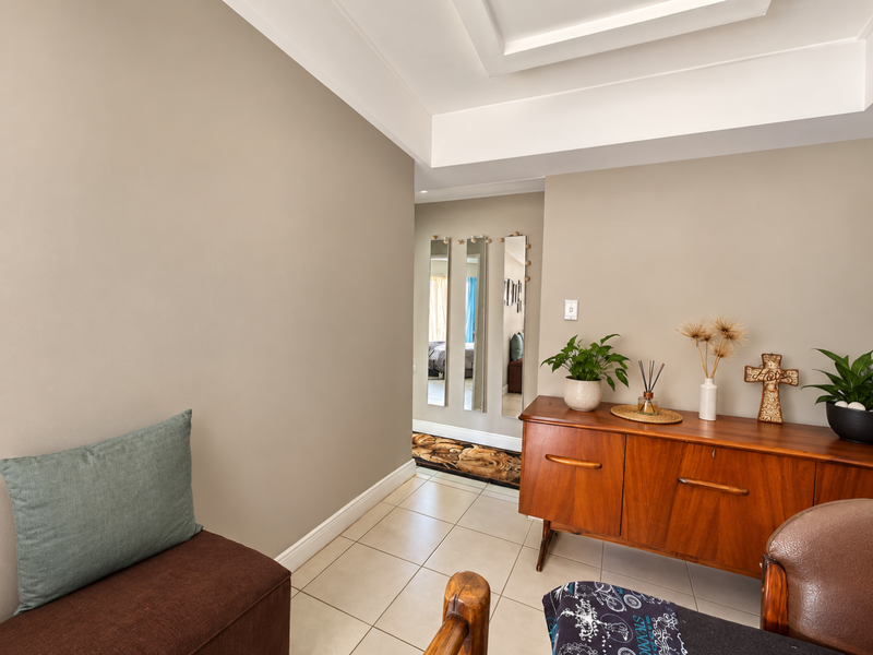 A well-maintained hallway featuring neutral wall tones, tiled flooring, and a recessed ceiling design, providing a clean and welcoming transition space.