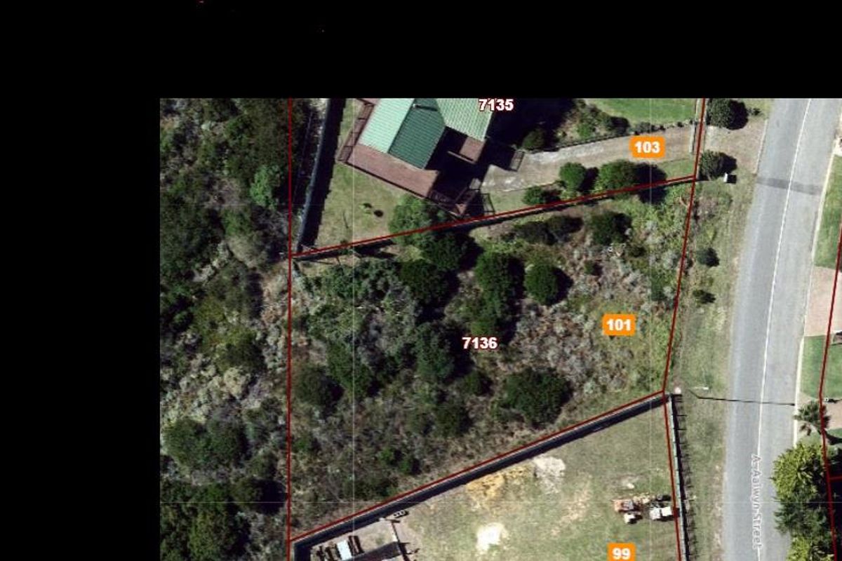 Aerial view of a vacant residential plot showing property boundaries, surrounding vegetation, and street access.