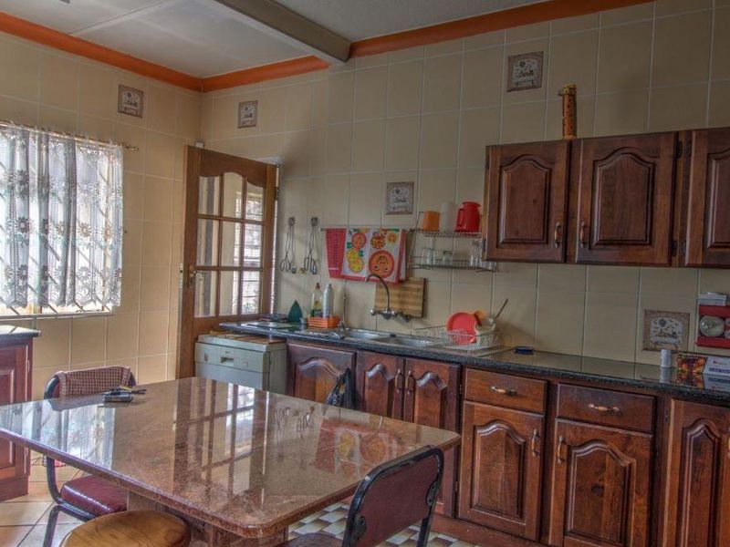 A functional kitchen featuring traditional wooden cabinetry, granite countertops, and a central island, offering a classic layout with ample storage and workspace.