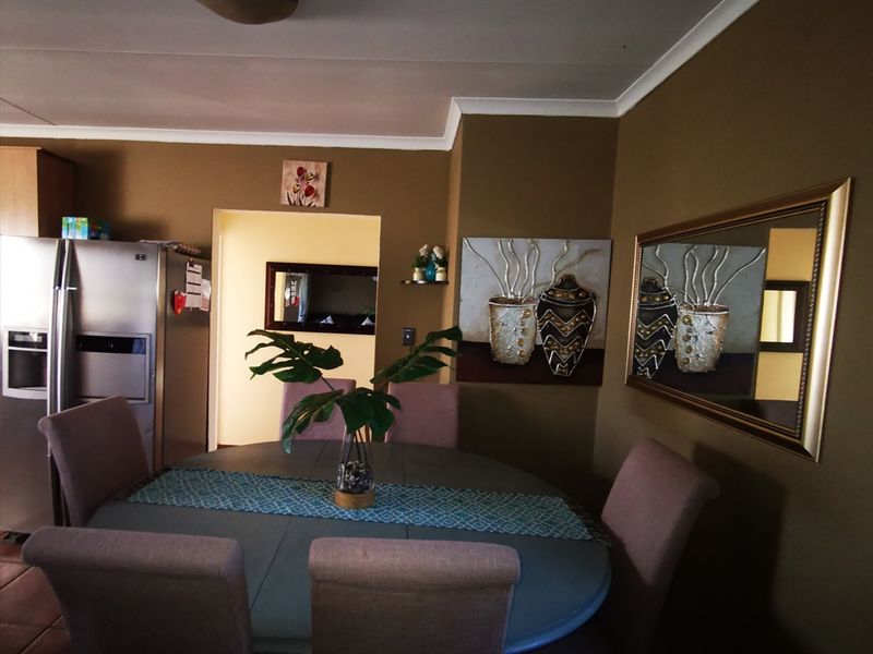A dining area featuring tiled flooring and decorative cove cornicing, providing a functional space for family meals.