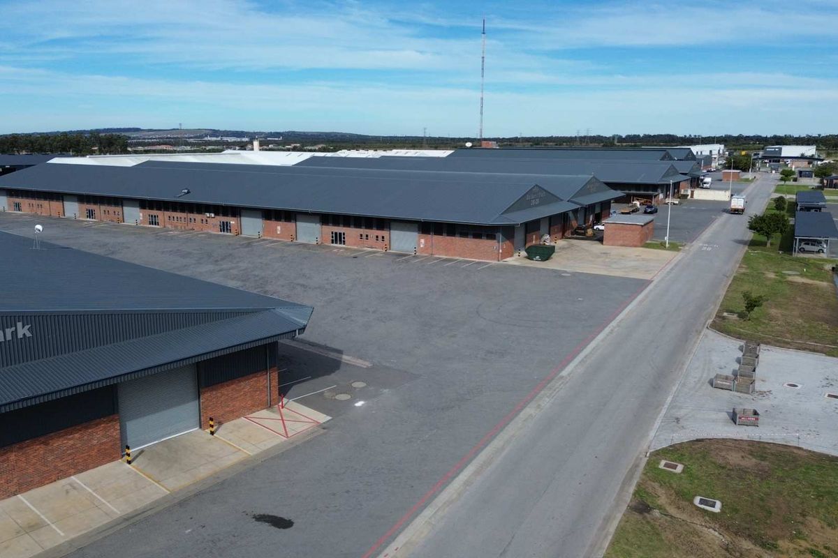 Aerial view of an industrial business park featuring multiple warehouse units with metal roofing, brick facades, and paved loading areas.