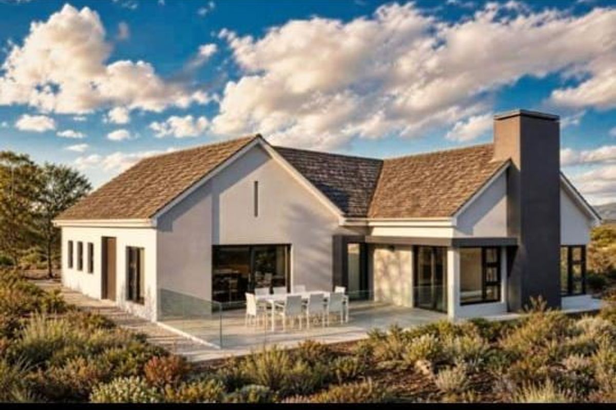 A modern rear elevation featuring a spacious paved patio, glass balustrades, and a prominent chimney, set against a landscaped garden.
