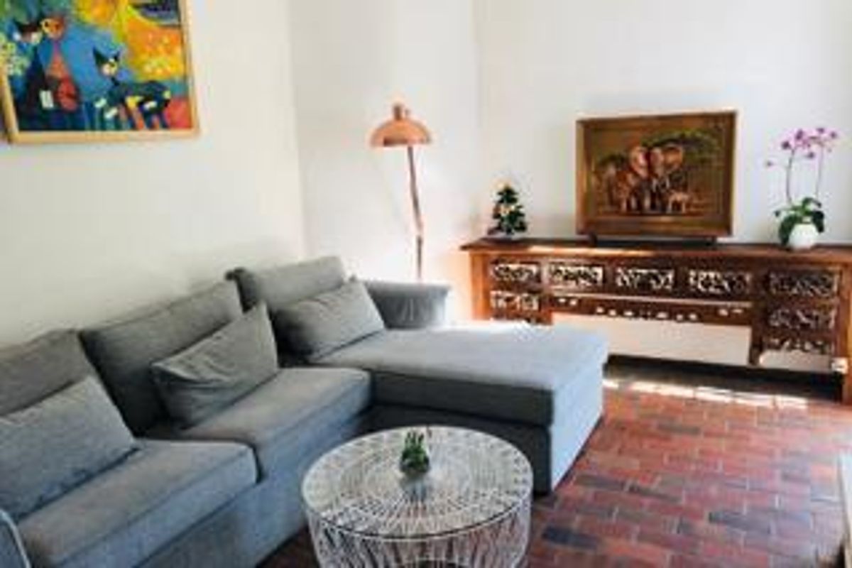 A comfortable living room featuring classic brick flooring and neutral walls, providing a warm and inviting space for relaxation.