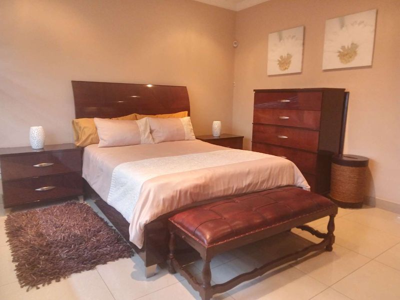 A well-maintained bedroom featuring neutral wall tones and tiled flooring, providing a comfortable and functional sleeping space.