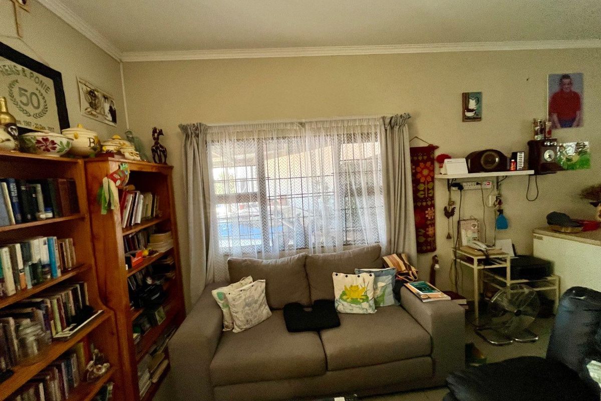 A living room featuring a window with security bars and neutral wall finishes.