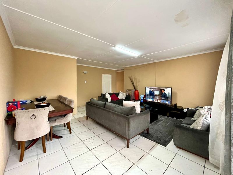 Open-plan living and dining area featuring tiled flooring and coved ceilings, providing a functional space for daily living.
