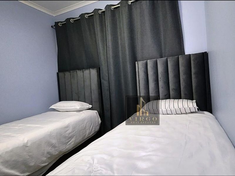 A compact bedroom featuring light blue walls and a simple layout, suitable for a guest room or children's bedroom.