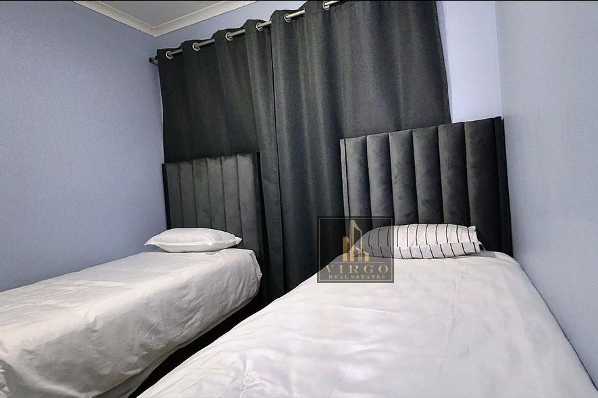 A compact bedroom featuring light blue walls and a simple layout, suitable for a guest room or children's bedroom.