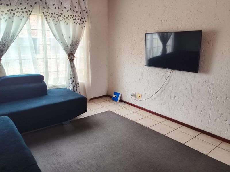 A living room featuring tiled flooring and textured wall finishes, providing a functional space for relaxation.