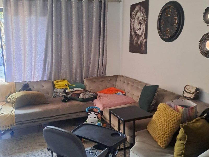 A living room area featuring neutral walls and a curtain rod, providing a functional space for relaxation.
