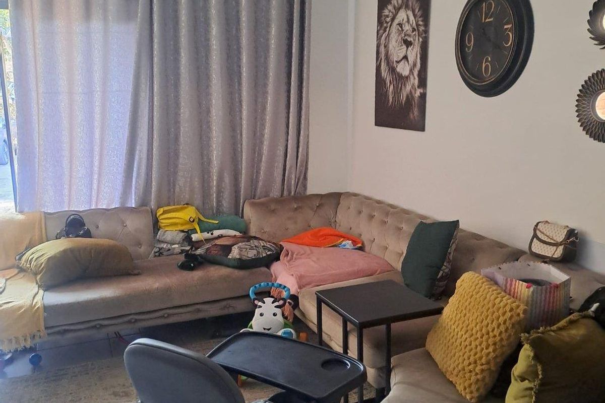 A living room area featuring neutral walls and a curtain rod, providing a functional space for relaxation.