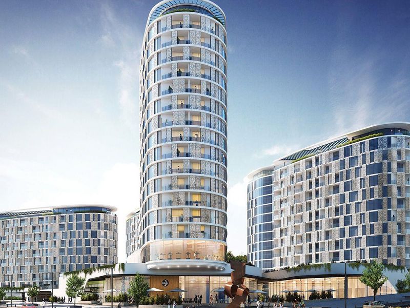 A modern high-rise apartment complex featuring contemporary architectural design, glass facades, and integrated balconies.