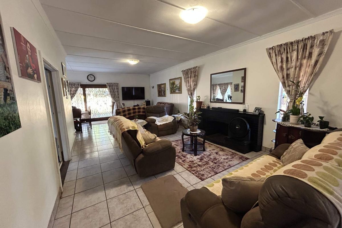 Spacious living room featuring tiled flooring, a built-in fireplace, and sliding glass doors providing access to the outdoor area.