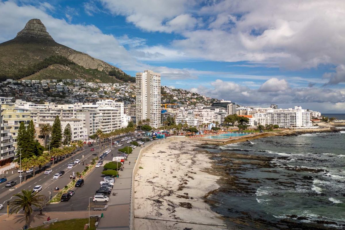 An aerial view of the coastal urban landscape, showcasing the proximity to the beach, ocean, and mountain backdrop.