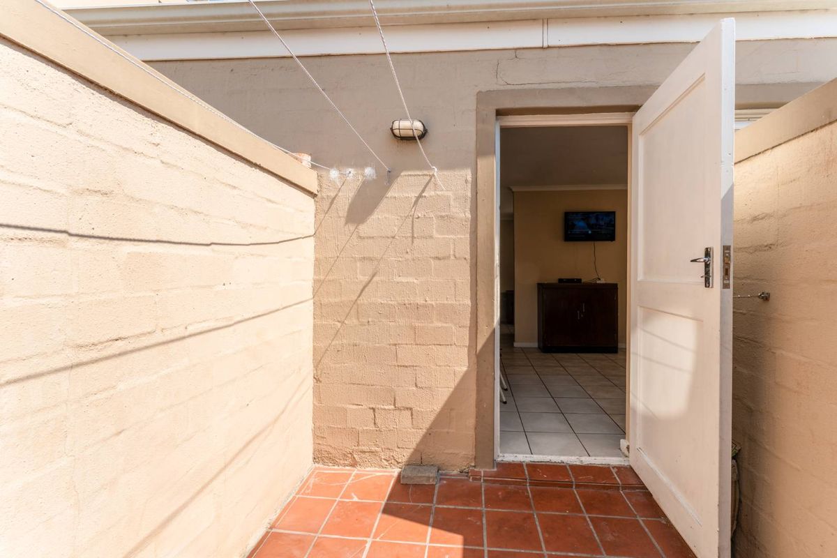 A small exterior courtyard area with tiled flooring and a doorway leading into the interior living space.