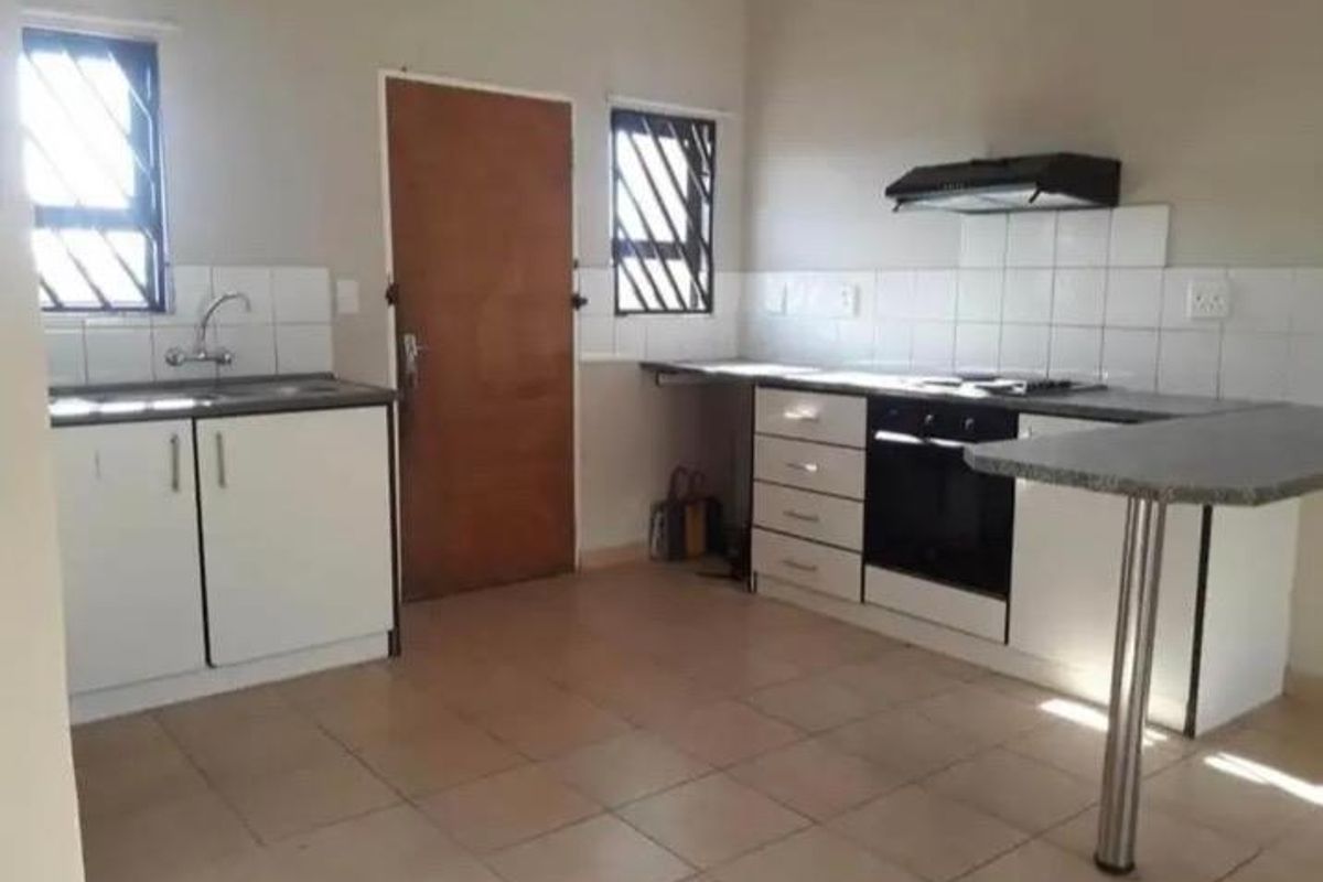 A functional kitchen featuring built-in cabinetry, a built-in oven with extractor fan, tiled backsplash, and tiled flooring.