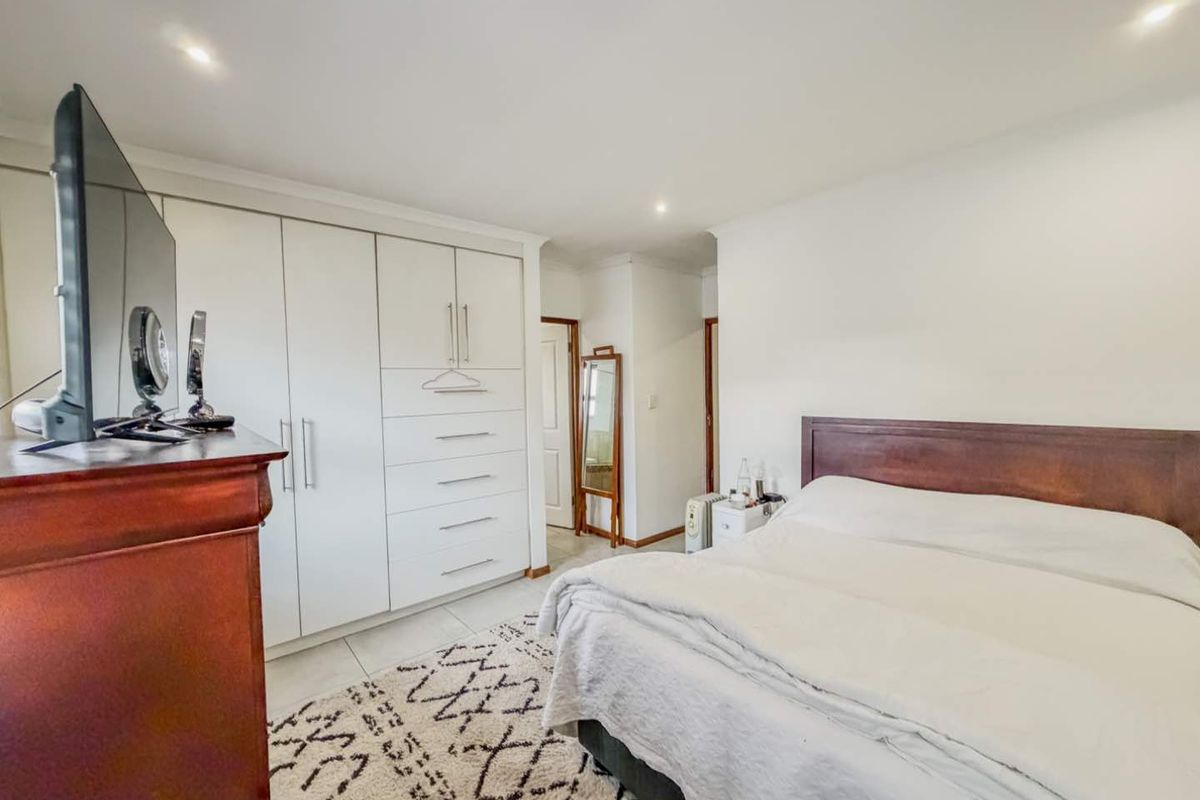 A well-maintained bedroom featuring built-in white cabinetry with integrated drawers and recessed ceiling lighting.