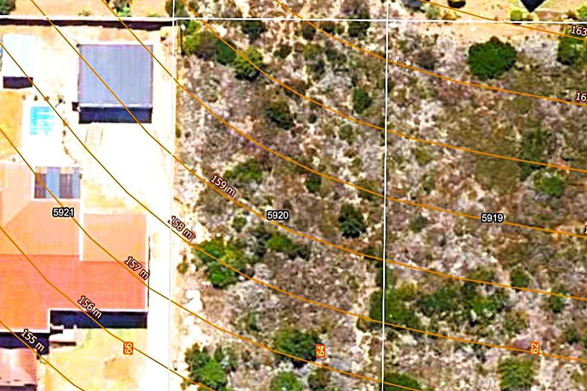 An aerial view of the residential land plot showing property boundaries, contour lines, and existing structures on the site.