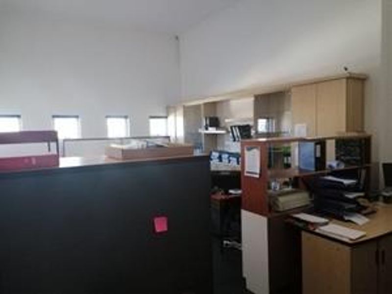 An office space featuring built-in cabinetry and partition walls, providing a functional layout for a professional work environment.