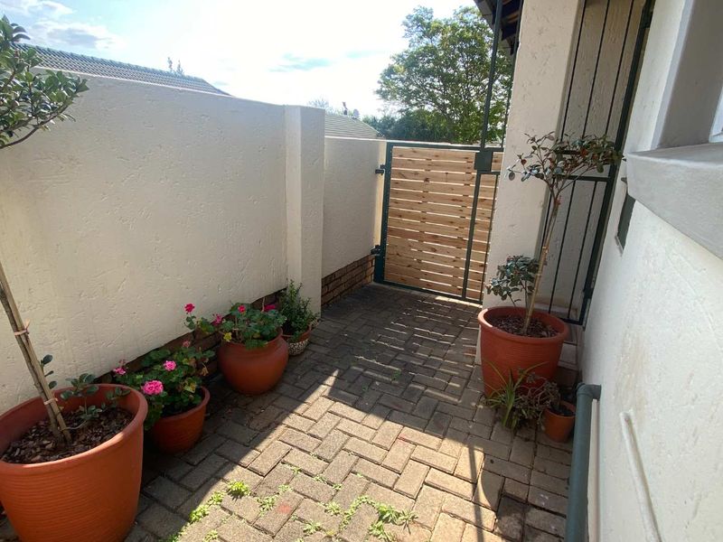 A private paved courtyard area featuring a boundary wall and a timber access gate, providing a secure and functional outdoor space.