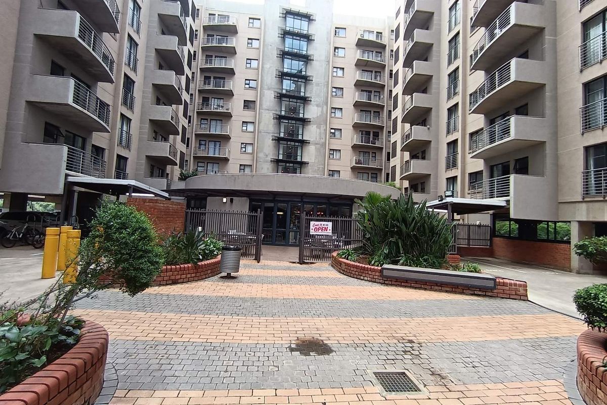 A view of the apartment complex courtyard featuring paved walkways, brick planter boxes, and multiple levels of balconies.