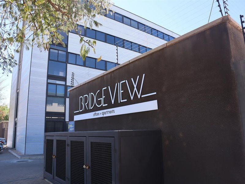 Exterior view of the Bridge View office and apartment building featuring modern metal cladding and secure perimeter fencing.