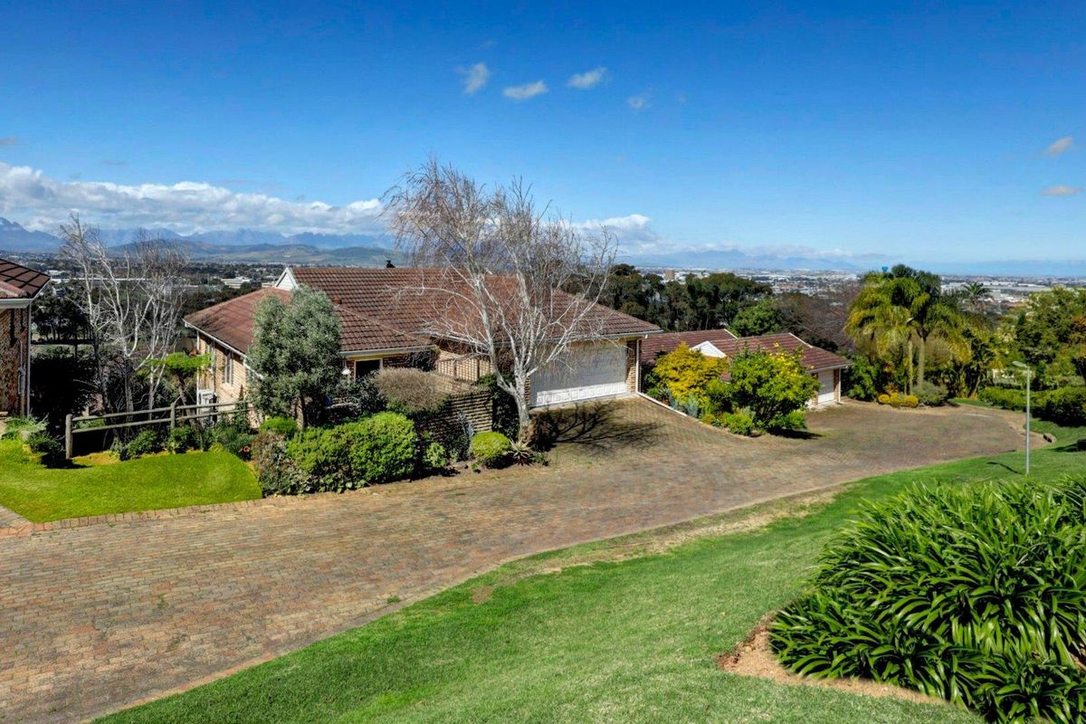 Elevated aerial view of a townhouse property featuring a paved driveway, tiled roof, and expansive mountain and city views.