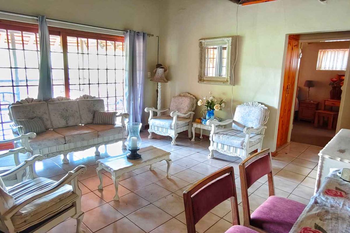 A living room featuring tiled flooring and large sliding glass doors that provide access to the outdoor area.