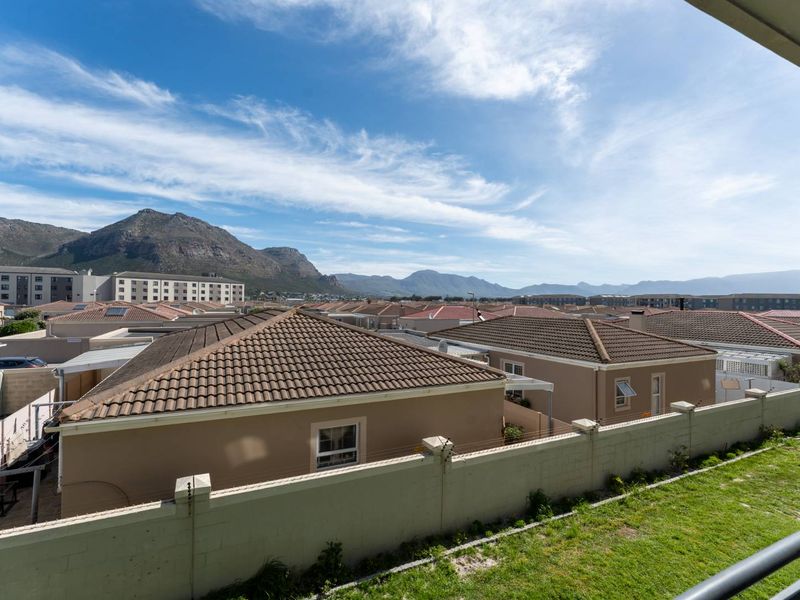 Elevated view overlooking a residential neighborhood with mountain vistas in the background.