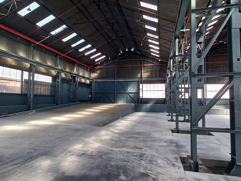 Spacious industrial warehouse featuring a robust steel portal frame, concrete flooring, and ample natural light provided by integrated roof skylights.