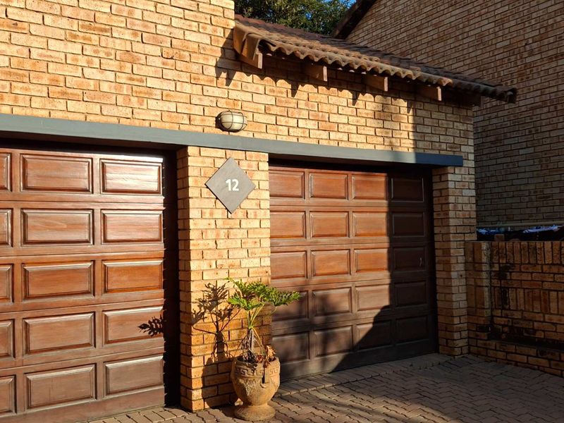 A well-maintained double garage featuring classic face brick construction and traditional wooden-style garage doors.