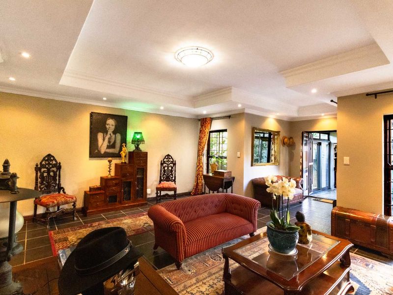 A spacious living room featuring a recessed ceiling with integrated downlights and durable tiled flooring, offering a comfortable and well-lit living environment.