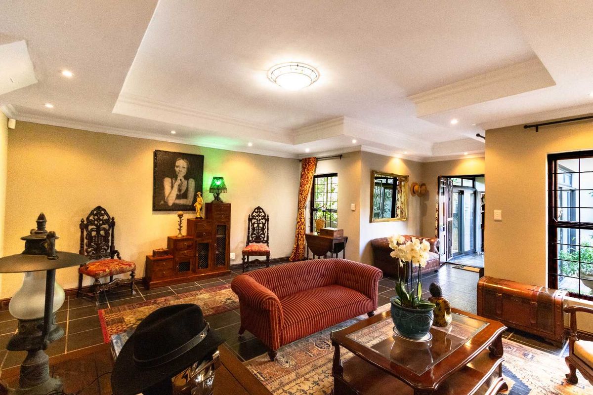 A spacious living room featuring a recessed ceiling with integrated downlights and durable tiled flooring, offering a comfortable and well-lit living environment.