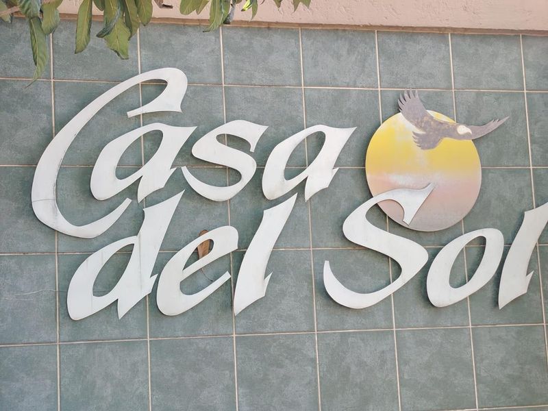 Exterior wall detail featuring the Casa del Sol building signage mounted on decorative tiled wall cladding.