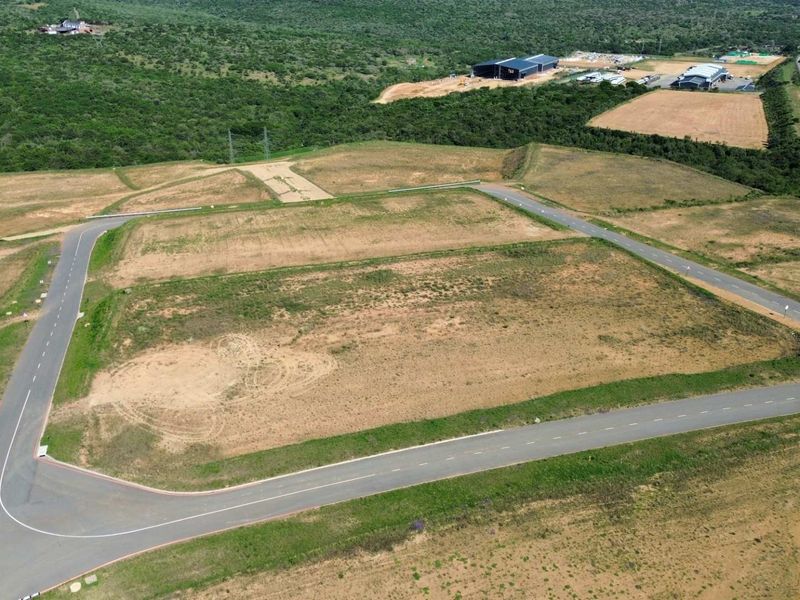 Aerial view of a cleared industrial land parcel featuring established paved access roads and surrounding infrastructure in a developing industrial estate.