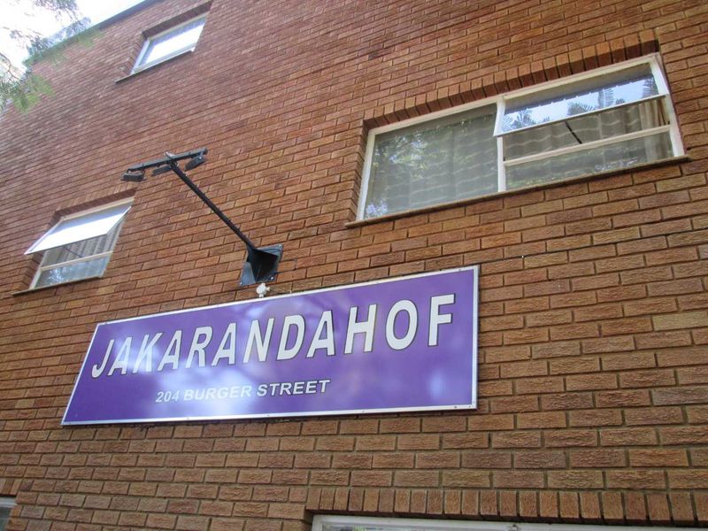 Exterior view of the Jakarandahof apartment building facade featuring brickwork and signage.