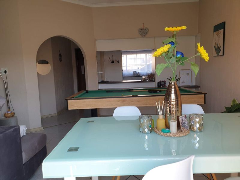 Open plan living and dining area featuring a classic archway and a convenient pass-through window connecting to the kitchen space.