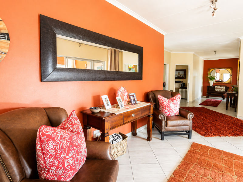 A spacious living area featuring tiled flooring and coved ceilings, with an open layout leading into adjacent rooms.